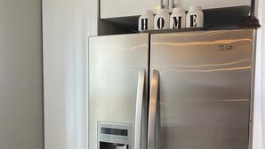 Ein Edelstahl-Kühlschrank mit integriertem Wasserspender und einem separaten Gefrierfach.