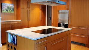 Une cuisine moderne avec des meubles en bois, un îlot central et des appareils électroménagers intégrés.