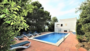 A rectangular swimming pool with a tiled deck, surrounded by lounge chairs and greenery. - Apartment in Playa de Pals Near Sandy Beach (Pals)