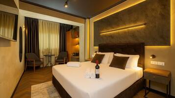 Een moderne hotelkamer met een groot bed, nachtkastjes, een bureau en een stoel.