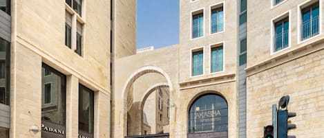Une vue de rue avec un grand bâtiment abritant de nombreux commerces, dont un magasin « Pandora » dont l’enseigne est bien visible.