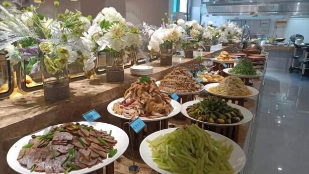 Un buffet proposant divers plats et agrémenté de compositions florales.