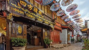 Un edificio tradicional con puertas de madera ornamentadas y un letrero con caracteres dorados.
