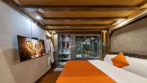 Una habitación de hotel con cama, televisión, baño y zona de ducha.