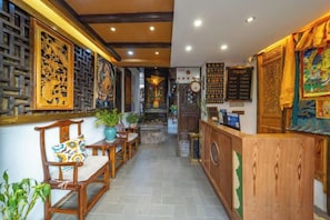 Un interior tradicional amb mobles de fusta, una taula de recepció i decoració mural.