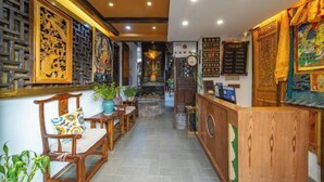 Decoración tradicional con muebles de madera, mostrador de recepción y elaborados adornos en las paredes.