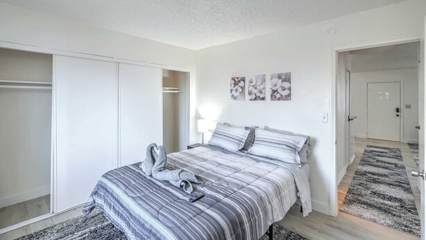 A bedroom with a bed, a wardrobe, a mirror, and a door leading to another room. - Your Vegas Home From Home! Sleeps 6! (Las Vegas)