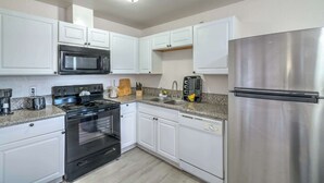 A kitchen with white cabinets, a stainless steel refrigerator, a microwave, an oven, and a granite countertop. - Your Vegas Home From Home! Sleeps 6! (Las Vegas)