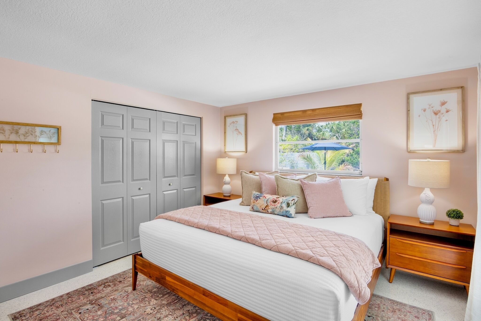 A bedroom with a bed, nightstands, a window with a view, and a wardrobe.