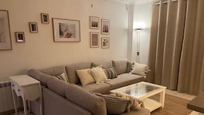 A living room with a beige sofa, a glass coffee table, a side table, and a radiator. - Spacious, family-friendly apartment, 5 min from La Mata Beach (La Mata)