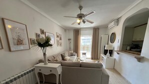 A modern living room with a beige sofa, a white side table, and a ceiling fan. - Spacious, family-friendly apartment, 5 min from La Mata Beach (La Mata)