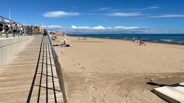 A beach with a wooden boardwalk, people sunbathing, and a clear blue sky. - Spacious, family-friendly apartment, 5 min from La Mata Beach (La Mata)