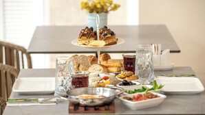 A table set with a variety of foods including pastries, bread, and a glass of water, suggesting a breakfast or snack setting. -  La Rubina Alacati-Adults Only (Cesme)