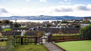 A residential area with houses, a gated entrance, and a view of a distant landscape.