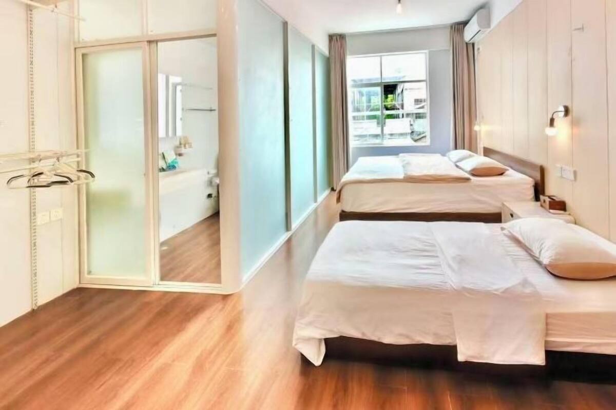 Ein Hotelzimmer mit zwei Betten, einer Schiebetür und Blick auf die Stadt.