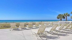 Een strandlounge met ligbedden en uitzicht op de oceaan.