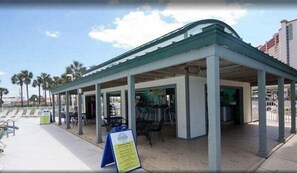 A covered outdoor seating area with a simple, open design and a few chairs.