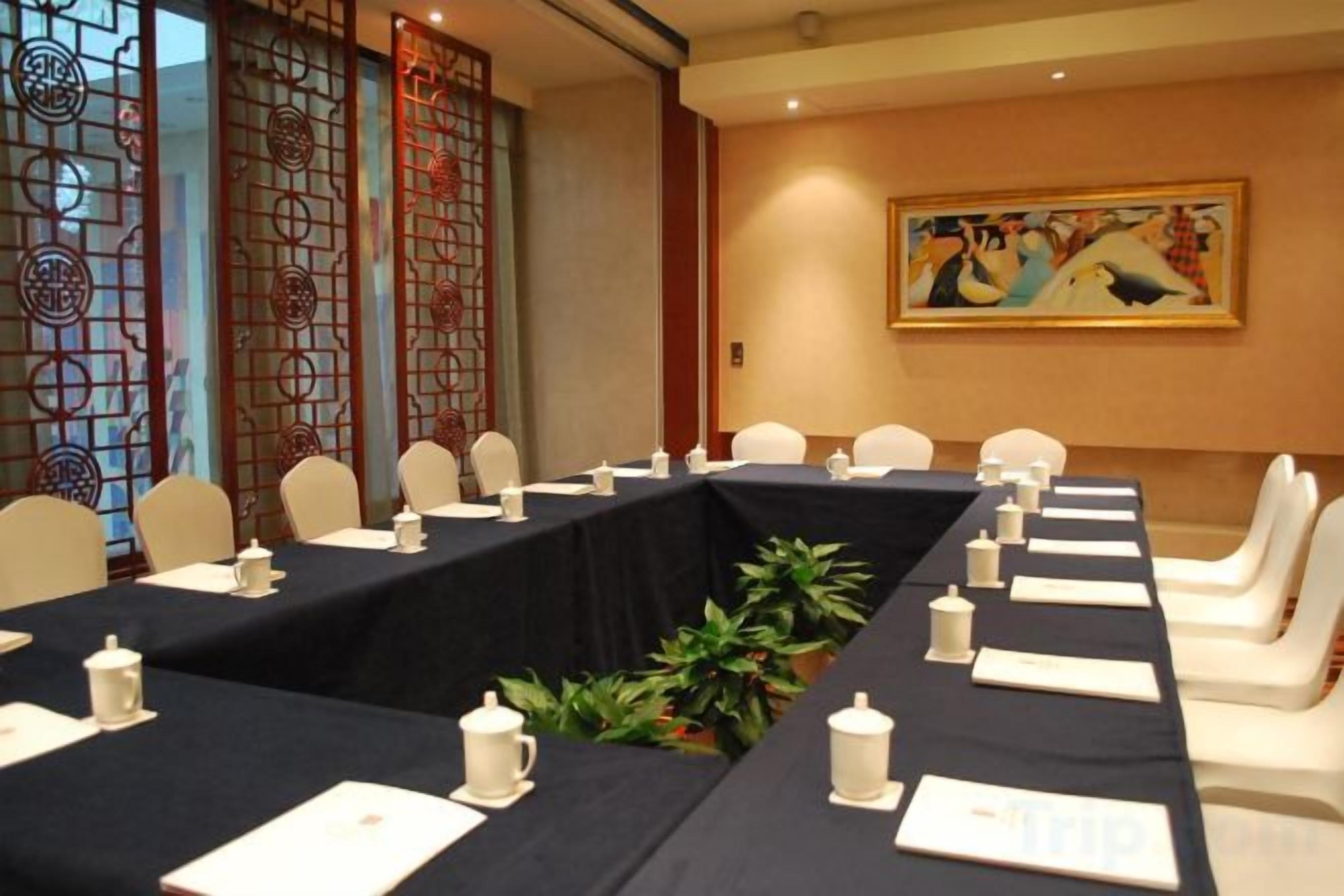 A conference room with a long table, chairs, and a decorative screen.