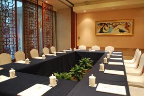 A conference room with a long table, chairs, and a decorative screen. - Grace Hotel (Suzhou)