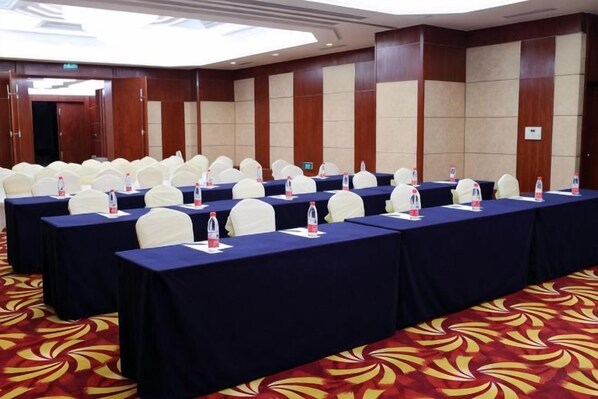 A conference room with multiple tables, chairs, and water bottles. - Grace Hotel (Suzhou)