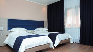 A hotel room with two beds, a large window with sheer curtains, and a wooden floor. - Al Bayt Hotel (Djelfa)