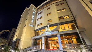 A hotel with a prominent sign, a staircase leading to the entrance, and a well-lit facade. - Al Bayt Hotel (Djelfa)