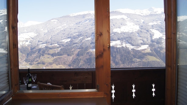 Une pièce dotée d’une grande fenêtre donnant sur un paysage montagneux.