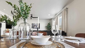 A dining table set with glass vases, a bowl, wine glasses, and cutlery. - Spacious 6BR - Sleeps 22 - Hot Tub & Pool Access (Meridian)