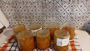 Diversi vasetti di vetro con etichette su un telo a scacchi.