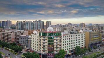 A multi-story hotel with a central dome structure, surrounded by a dense urban environment with high-rise buildings.