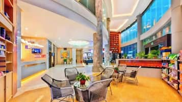 A spacious lobby with a curved ceiling, seating area, and a reception desk.
