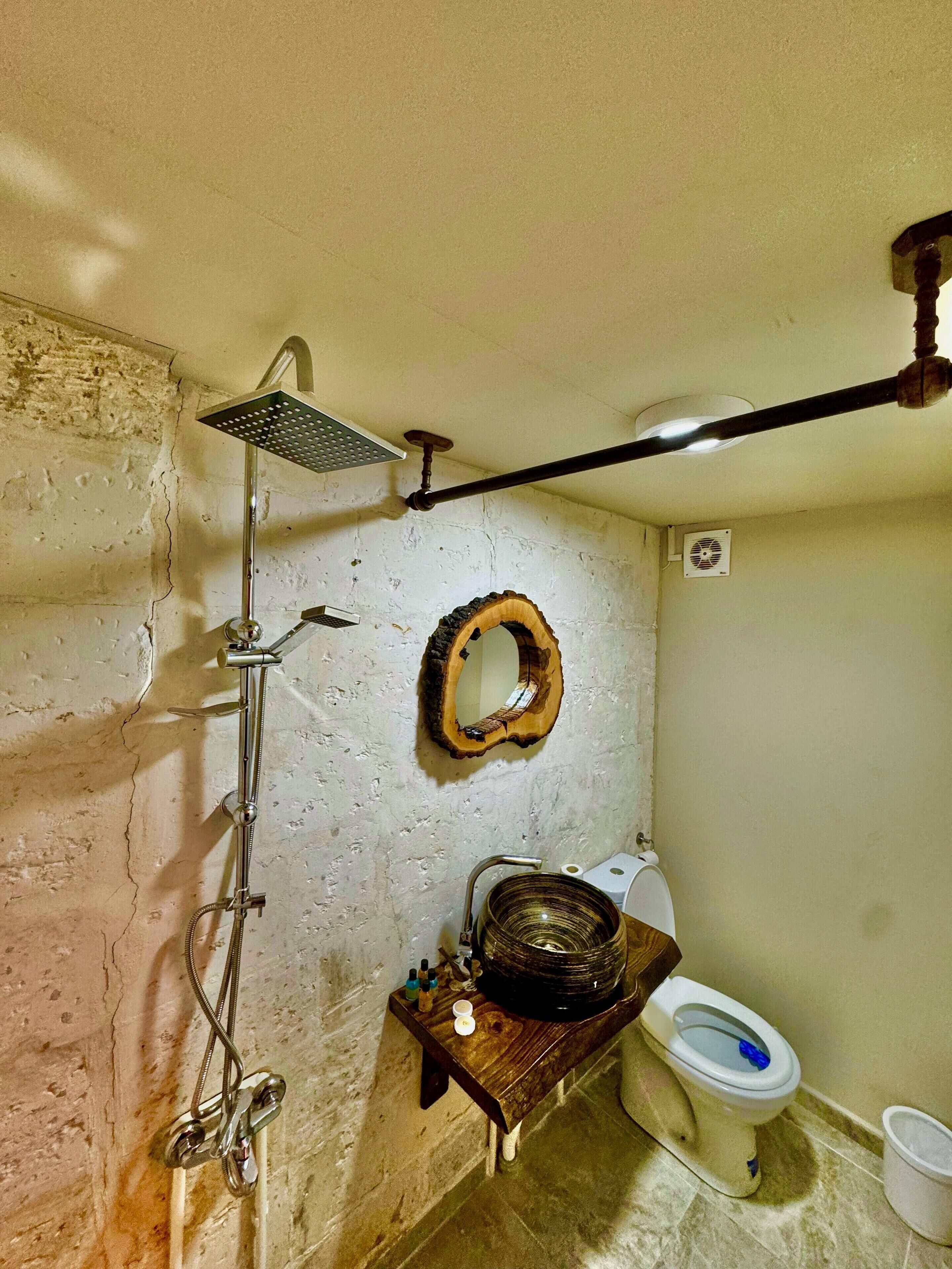A bathroom with a shower, a toilet, and a sink.