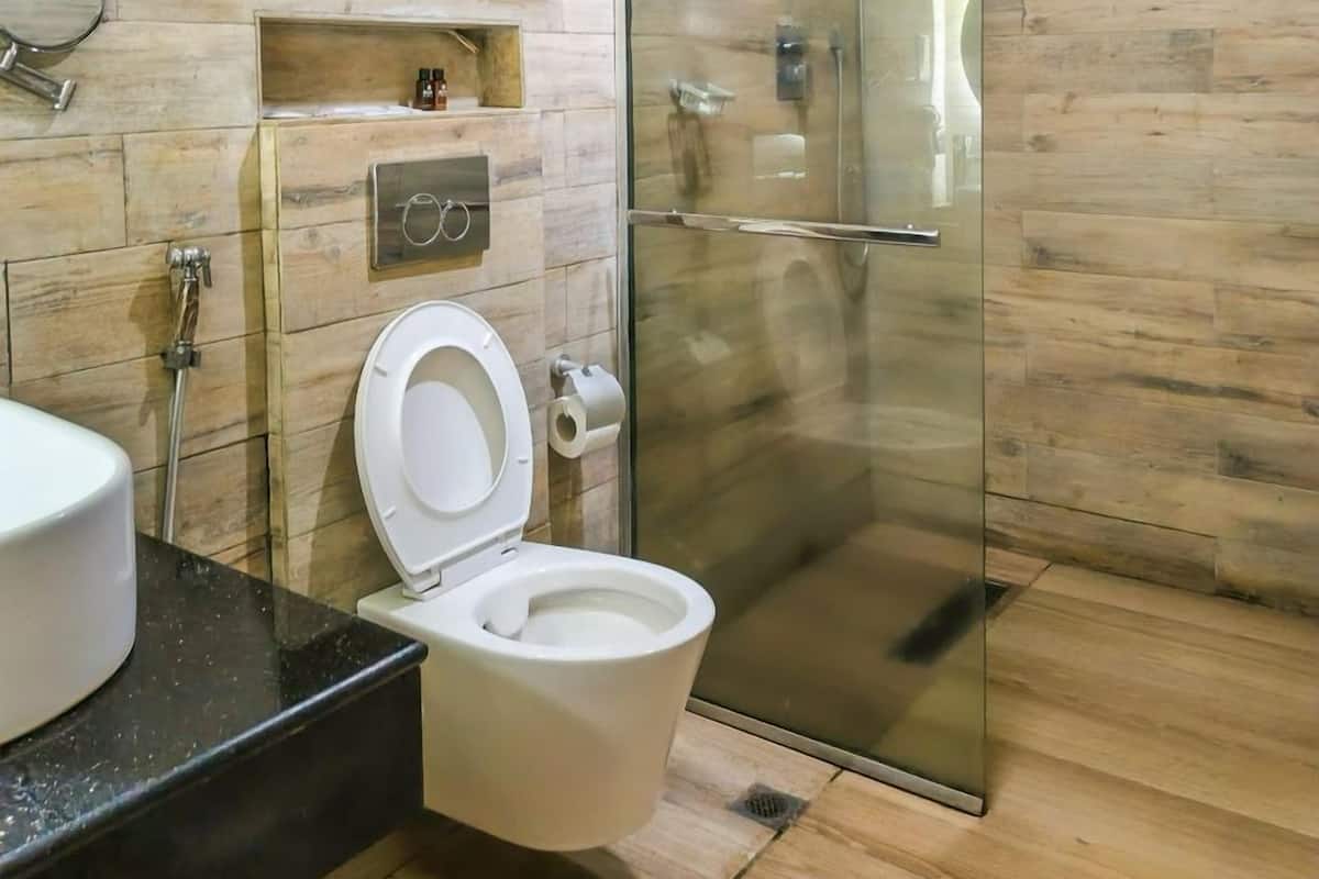Une salle de bain moderne avec des toilettes, une douche à parois de verre et un mur en bois.