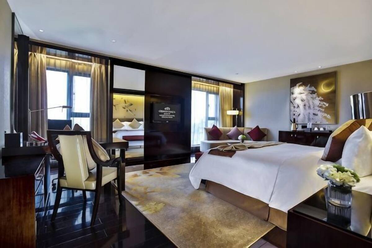 Ein geräumiges Hotelzimmer mit einem großen Bett, einem Schreibtisch und einem Sessel.