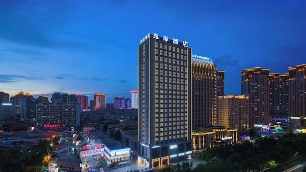 A high-rise hotel with multiple floors and a prominent sign at the top. - UrCove by Hyatt Aksu Century Square (Aksu)