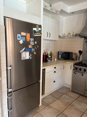 A kitchen with stainless steel appliances, white cabinets, and a tiled backsplash. - Villa in Saint Jeannet in the Nice hinterland; sleeps 10; fenced-in garden (Saint-Jeannet)