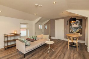 Een moderne woonkamer met een bank, een salontafel en een lamp.