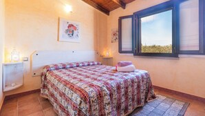 A bedroom with a bed, a nightstand, a window with a view, and a wall-mounted light fixture. - IN OROSEI APARTMENT WITH SEA VIEW VERANDA (OROSEI)