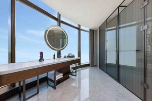 Ein modernes Badezimmer mit großem Spiegel, Waschtisch und Duschkabine aus Glas.