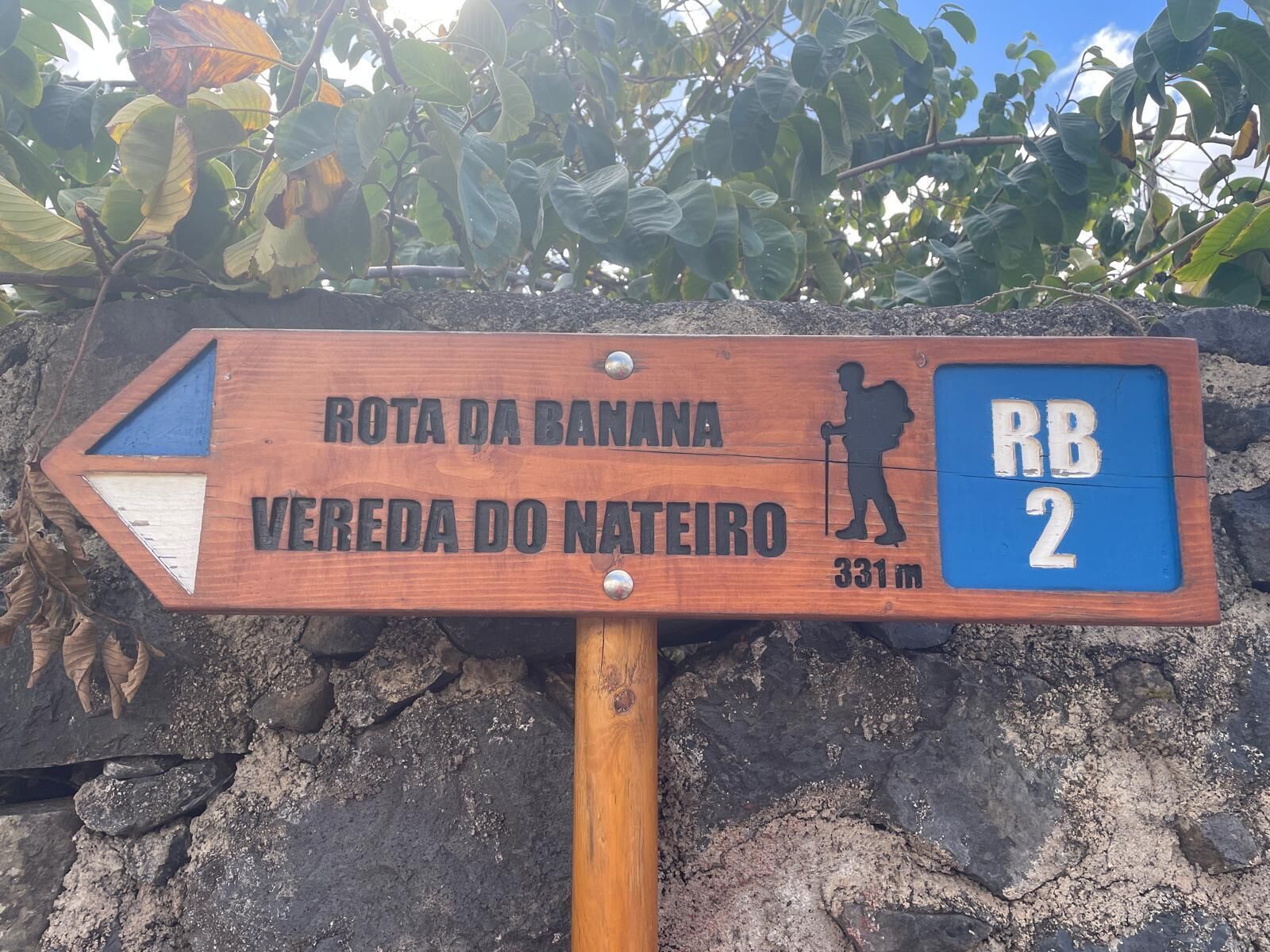 Een houten bord met een wandelpictogram en de tekst 'ROTA DA BANANA' en 'VEREDA DO NATEIRO', met een hoogte van 331 meter.