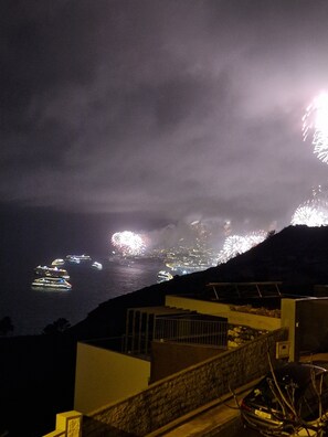 Blick auf die Küste mit Booten und Feuerwerk.