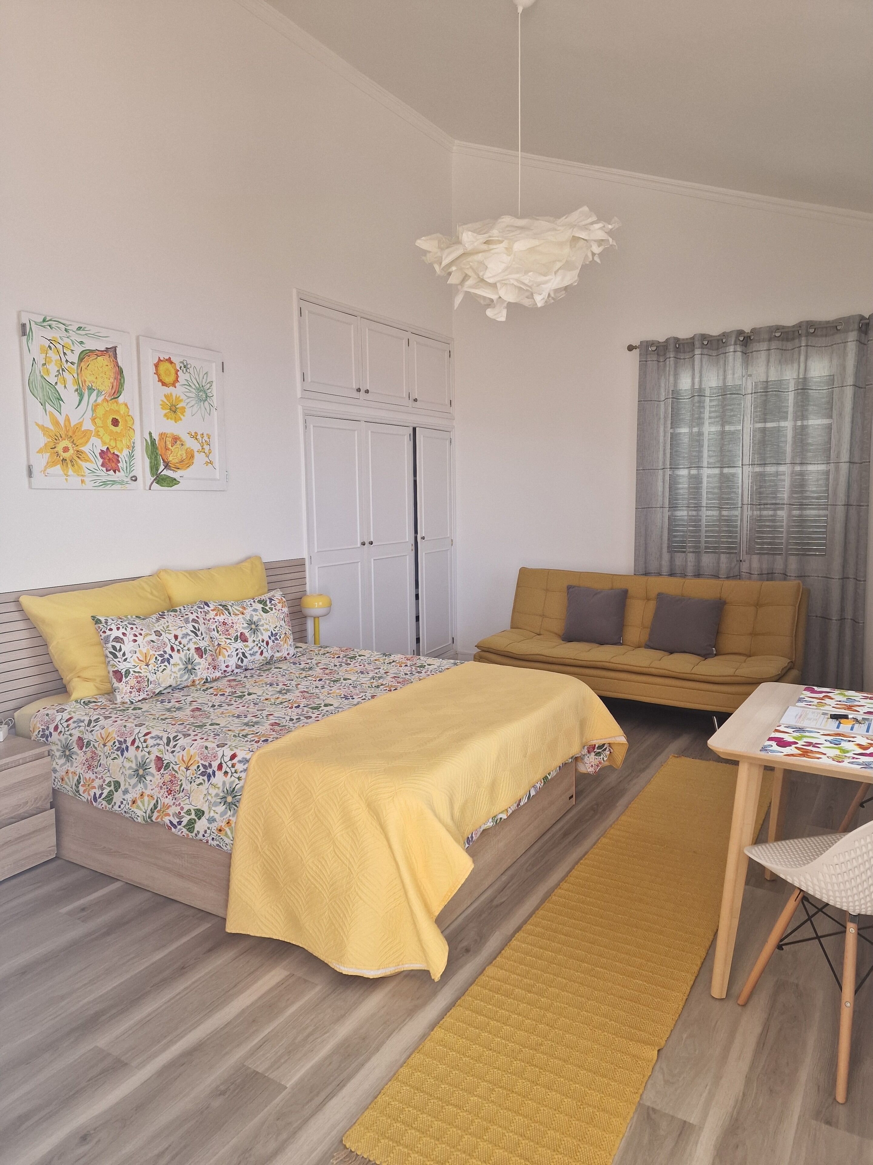 Ein Schlafzimmer mit einem Bett, einem Sofa, einem Tisch und einem Sessel.