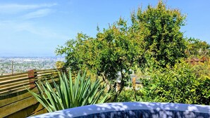 A hot tub with a clear view of a cityscape in the background. - Hills Cottage with Panoramic Views & Hot Tub. Pet Friendly! (Oakland)
