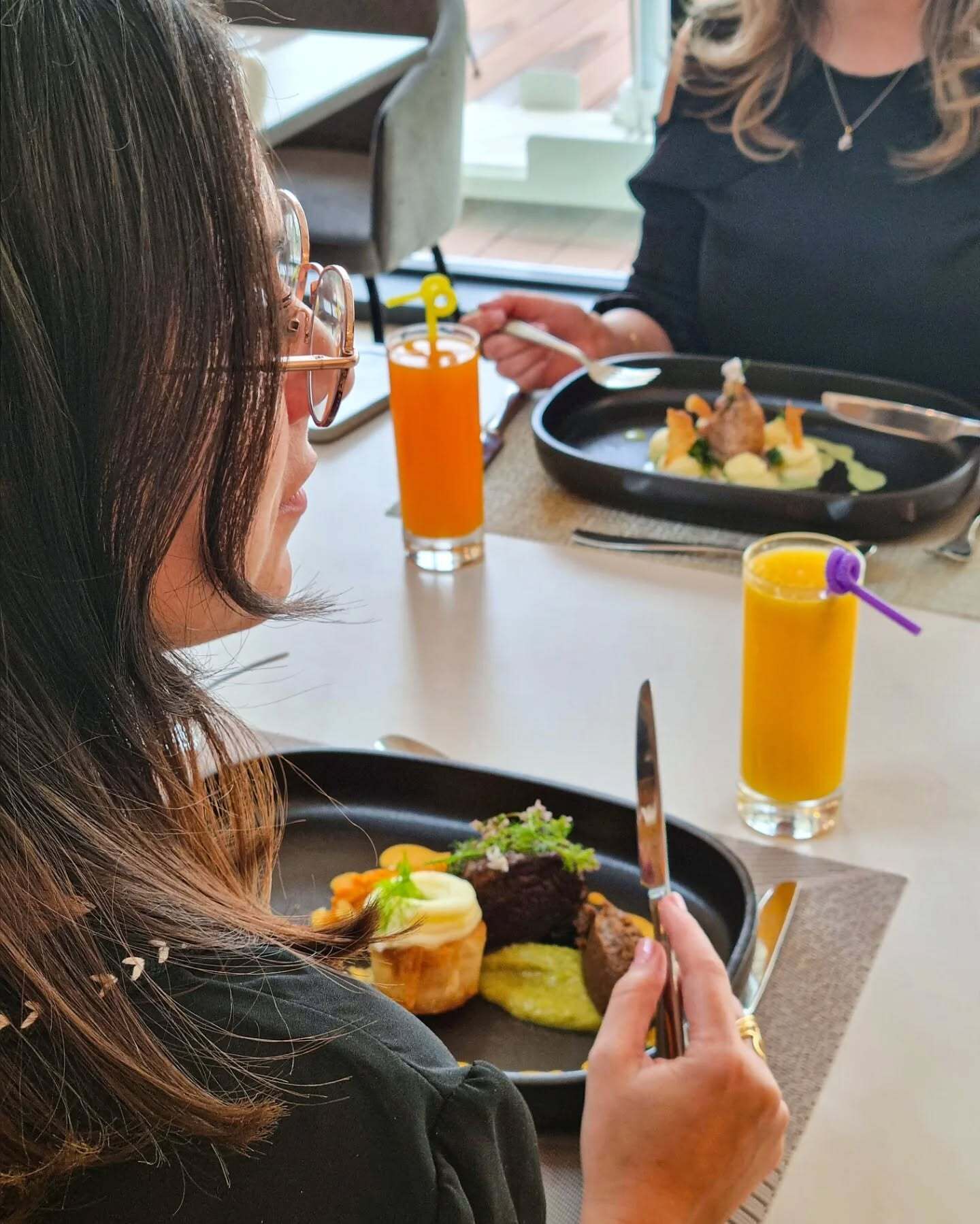 A person dining at a table with a meal and drinks.