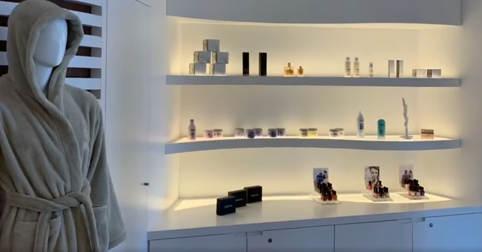 A modern retail display with multiple shelves, featuring various products.