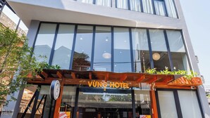 Uma entrada de hotel moderna com uma placa que diz "VUNG HOTEL".