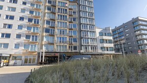 A multi-story building with balconies, a restaurant named 'San Marino', and a 'The Golden M' establishment. - Modern Studio With sea View (Middelkerke)