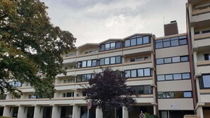 A multi-story residential building with a flat roof, large windows, and a central entrance. - Vacation apartment Storm am Holm (Schönberg)