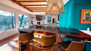 A modern kitchen with a large island, bar stools, and a hanging light fixture. - Winding Down at Lake Ann - Stunning Views Await! (Bella Vista)