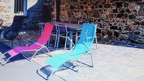 An outdoor seating area with stone walls and a table. - For rent, single-storey farmhouse with large grounds. not enclosed (Lamballe-Armor)
